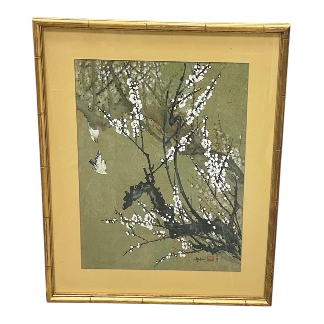 Framed Asian Floral Branch Print: Decorative print depicting flowering tree branches adorned with delicate white blossoms against a muted green background. The composition includes a small bird in flight and is executed in an East Asi