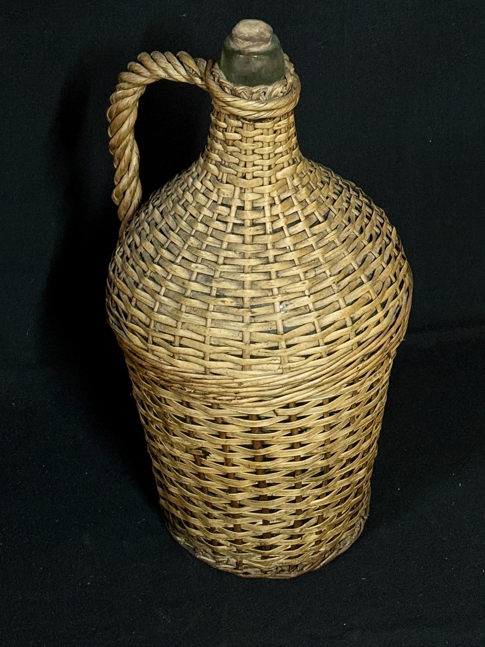 Old Glass Bottle Large Wicker Covered Wine Olive Oil Cask: ITEM: Large Wicker Covered Wine Olive Oil Cask Hand blown bottle completely encased with wicker. Twisted wicker handle woven into the case at mid section. Glass has taken on an aqua color as oxidation
