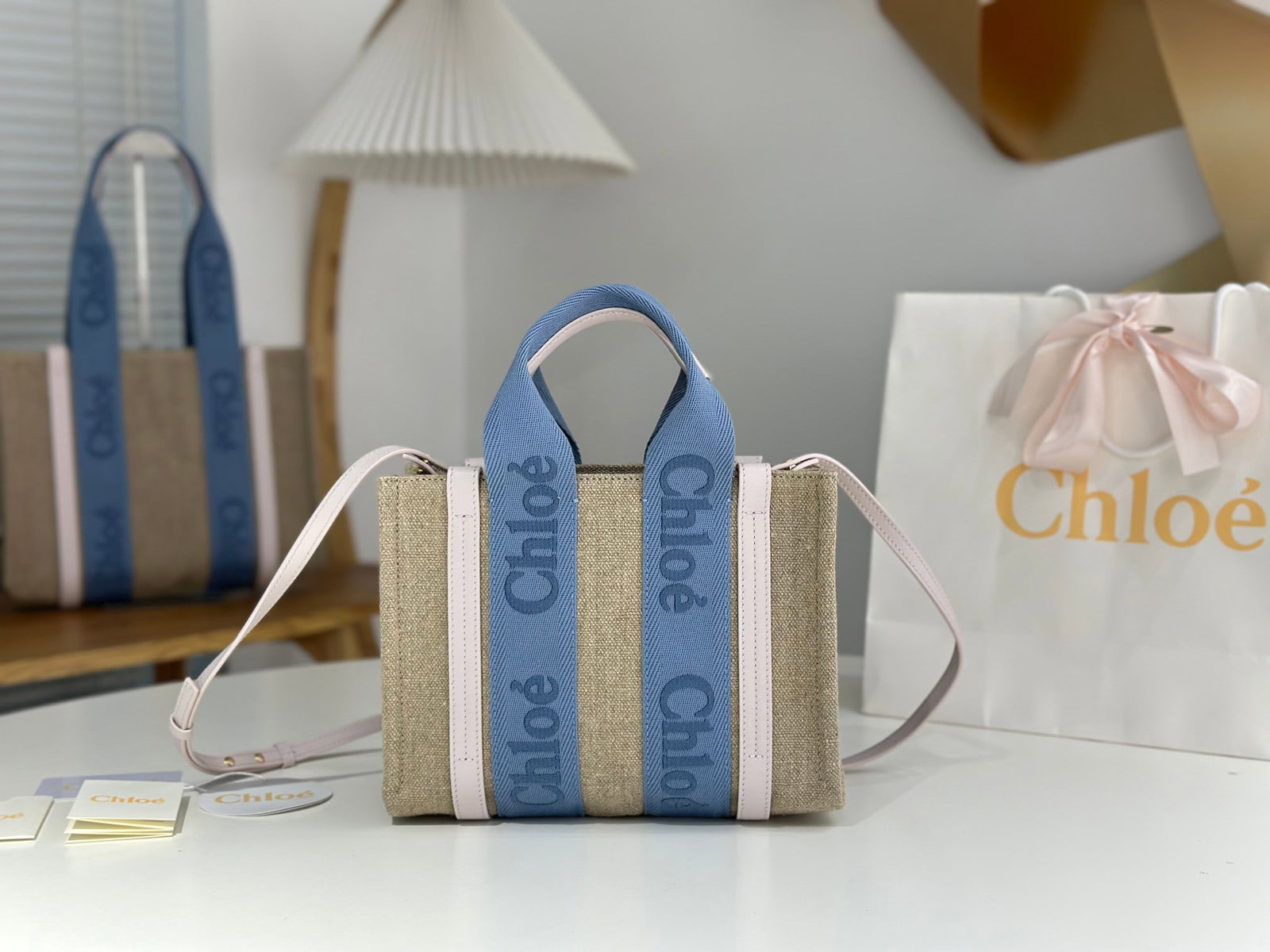 Chloe woody Tote: The small size Chloe Woody Tote is absolutely gorgeous. The creamy pink color with blue webbing is stunning. The bag is still made of eco-friendly, high-resilience linen. "A key difference from previo