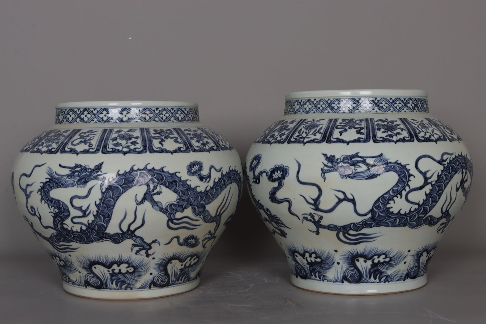 A pair of Yuan Dynasty blue and white porcelain jars with double dragons and floral patterns amidst (1 of 9)