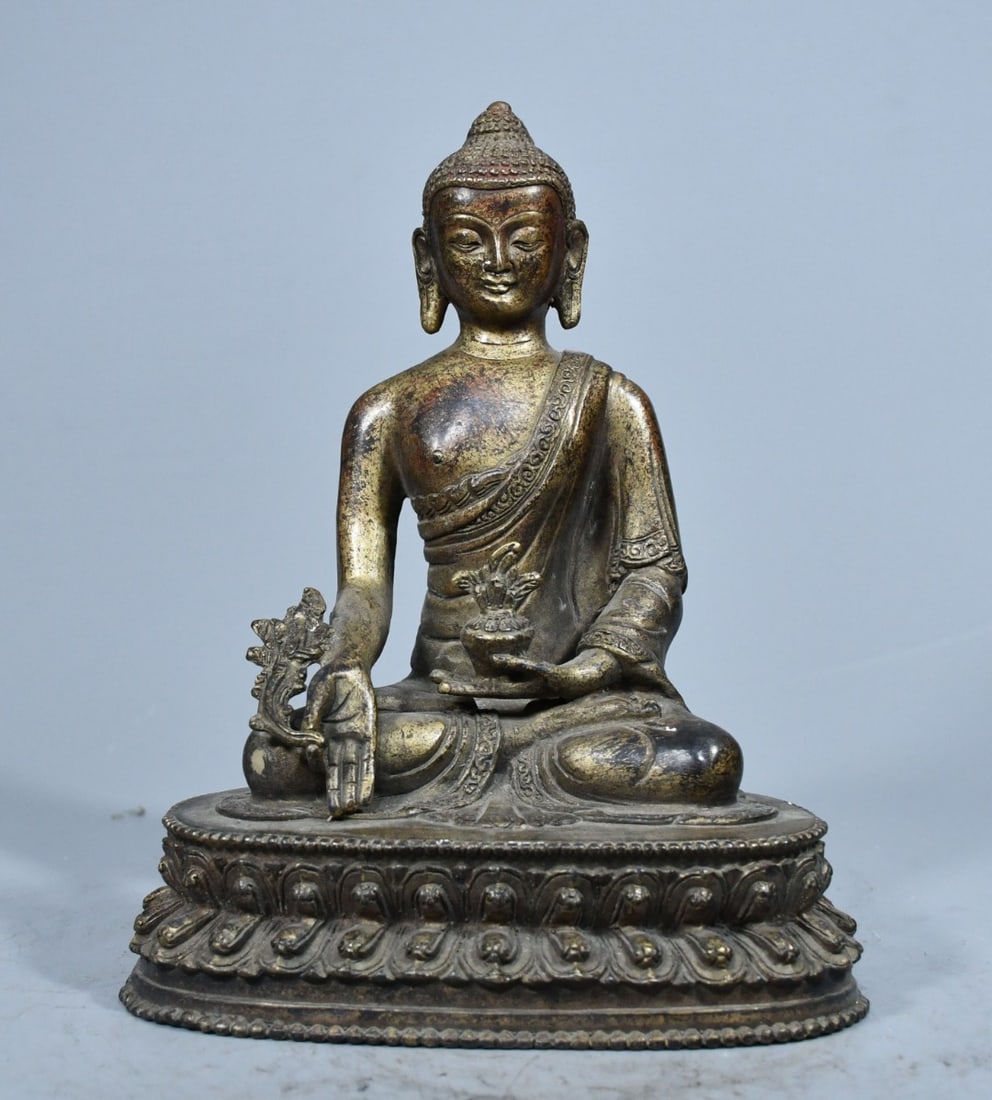 The old bronze Medicine Buddha statue is thick and heavy, meticulously crafted, with an elegant: This antique brass Medicine Buddha statue is made with a thick, heavy body, meticulously crafted, and possesses an elegant color and a rich, natural patina. The statue is deeply cast and possesses sig