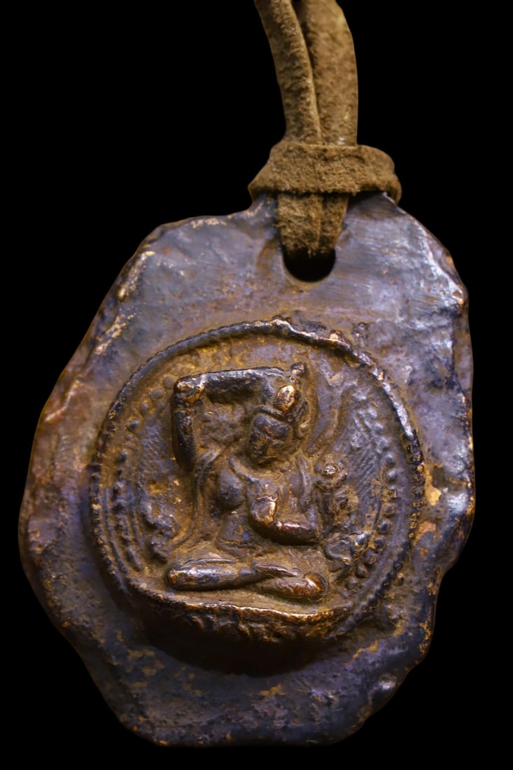 Copper-bodied, hand-hammered and engraved Buddha amulets: This copper-bodied, hand-hammered and engraved Buddha amulet measures 6.3 cm in height, 4.5 cm in width, and weighs approximately 108 g. Provenance:Private collection from a professor in Newcastle