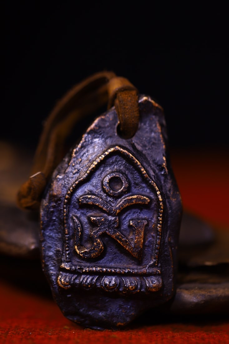 Copper-bodied, hand-hammered and engraved Buddha amulets: This copper-bodied, hand-hammered and engraved Buddha amulet measures 5.8 cm in height, 3.6 cm in width, and weighs approximately 110 g. Provenance:Private collection from a professor in Newcastle
