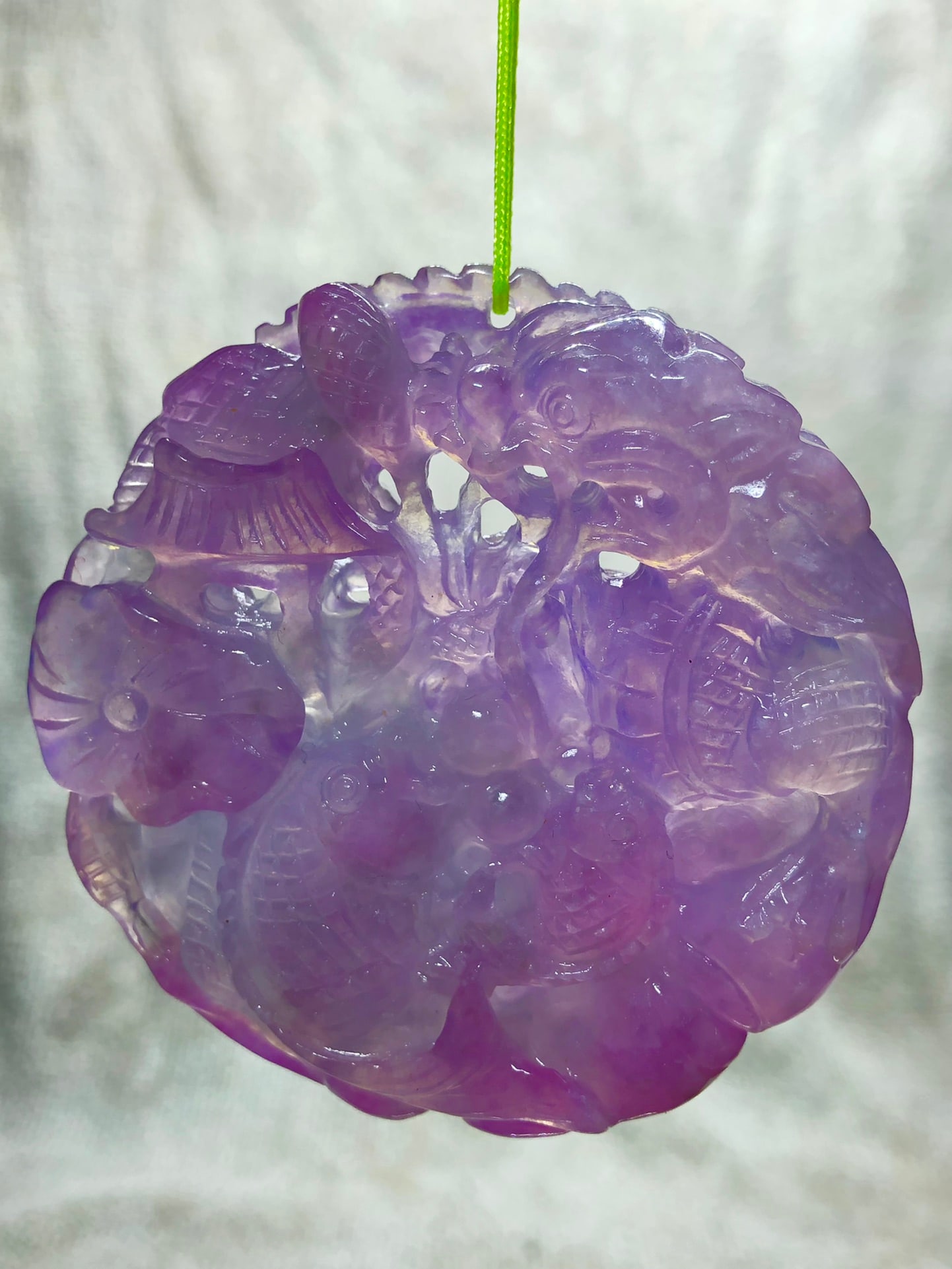 High-grade icy violet jadeite double-sided openwork round pendant: This is a high-quality, icy violet jadeite double-sided openwork round pendant. It is meticulously hand-carved, with beautiful color, a smooth and lustrous patina, and an elegant appearance. It is in