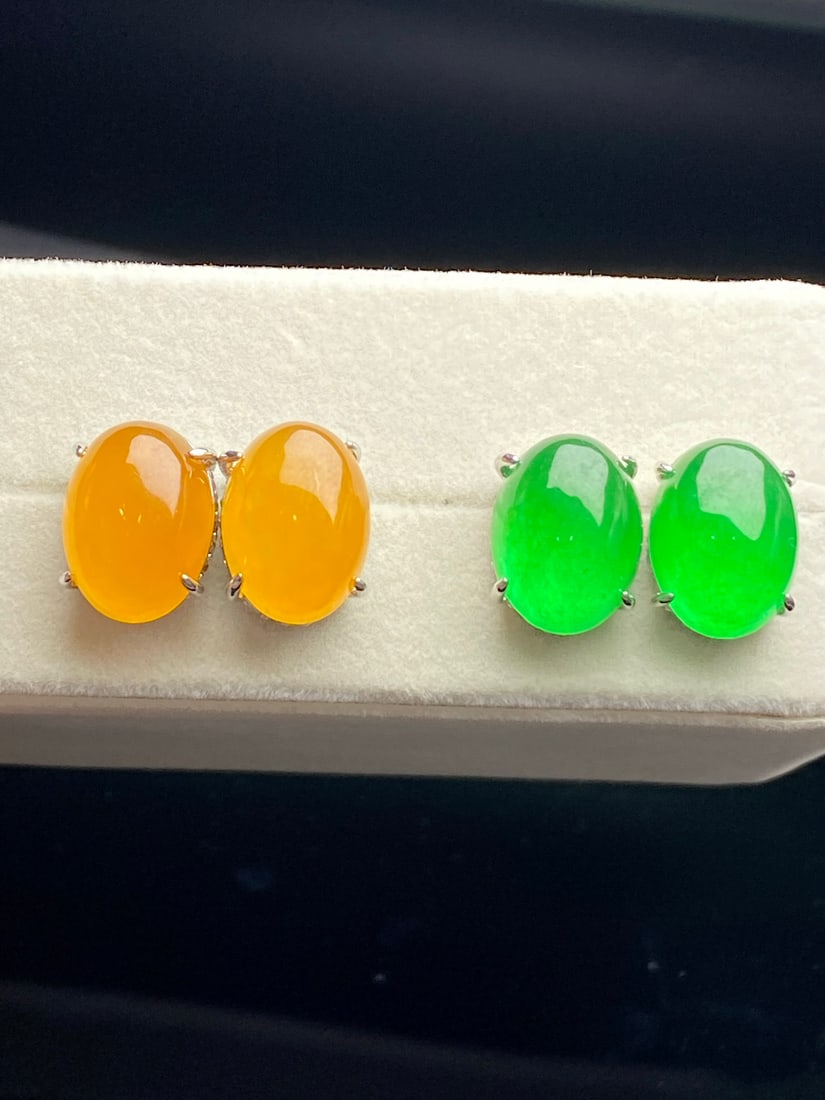 Jadeite earrings made of icy yellow jadeite, fully green in color.: Jadeite earrings made of icy yellow jadeite, full green in color, are lustrous and translucent, exquisitely three-dimensional, and perfectly flawless. Provenance:from the collection of George Stopher,