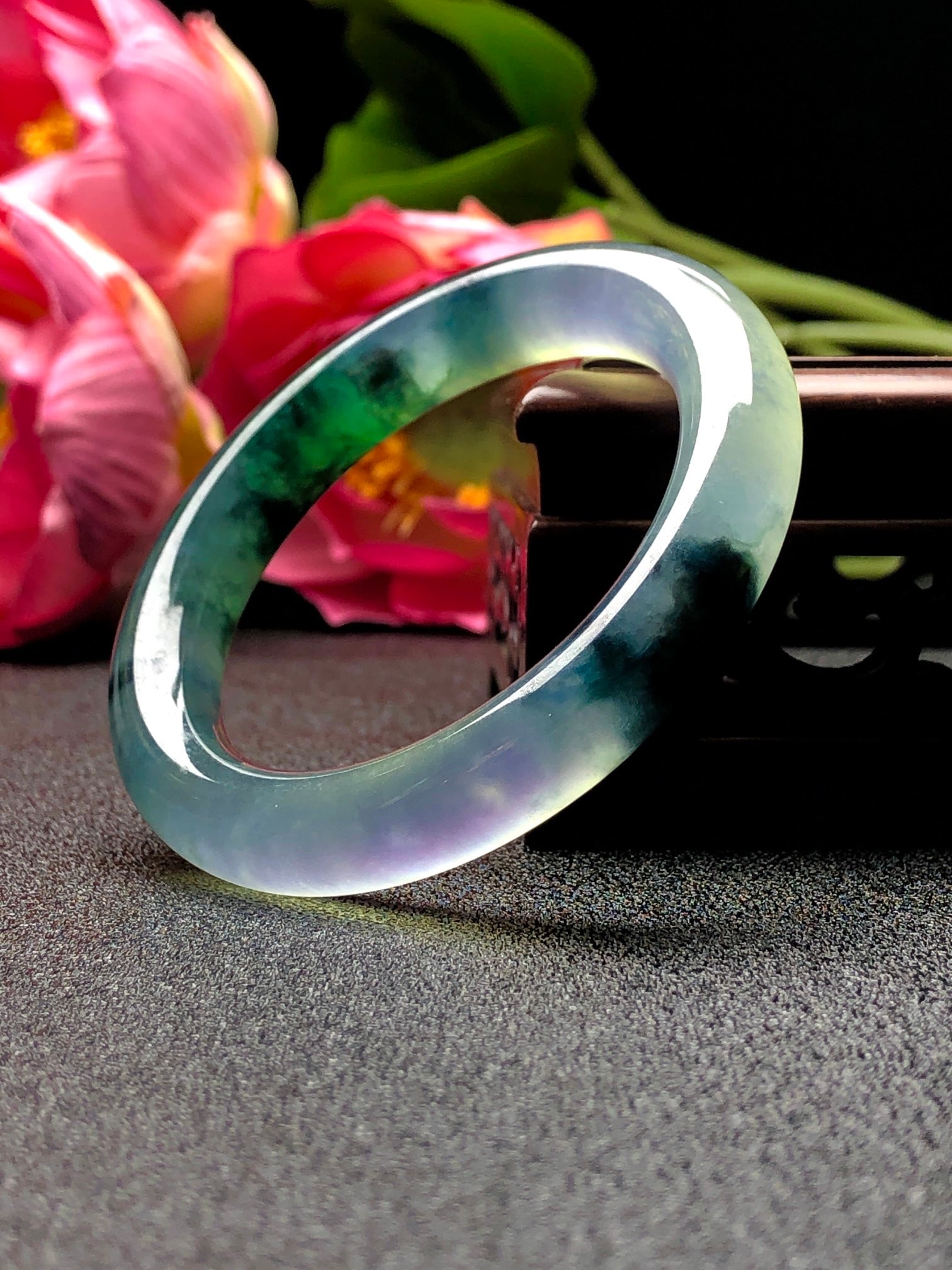 A high-ice, high-fluorescence, floating flower round jadeite bangle: A high-quality, highly fluorescent, round jadeite bangle with floating floral patterns. The bangle features a landscape design, is made from superior material, is icy and translucent with a smooth, ro