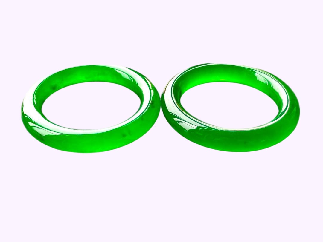 A pair of imperial green high-ice jadeite round bracelets (1 of 7)