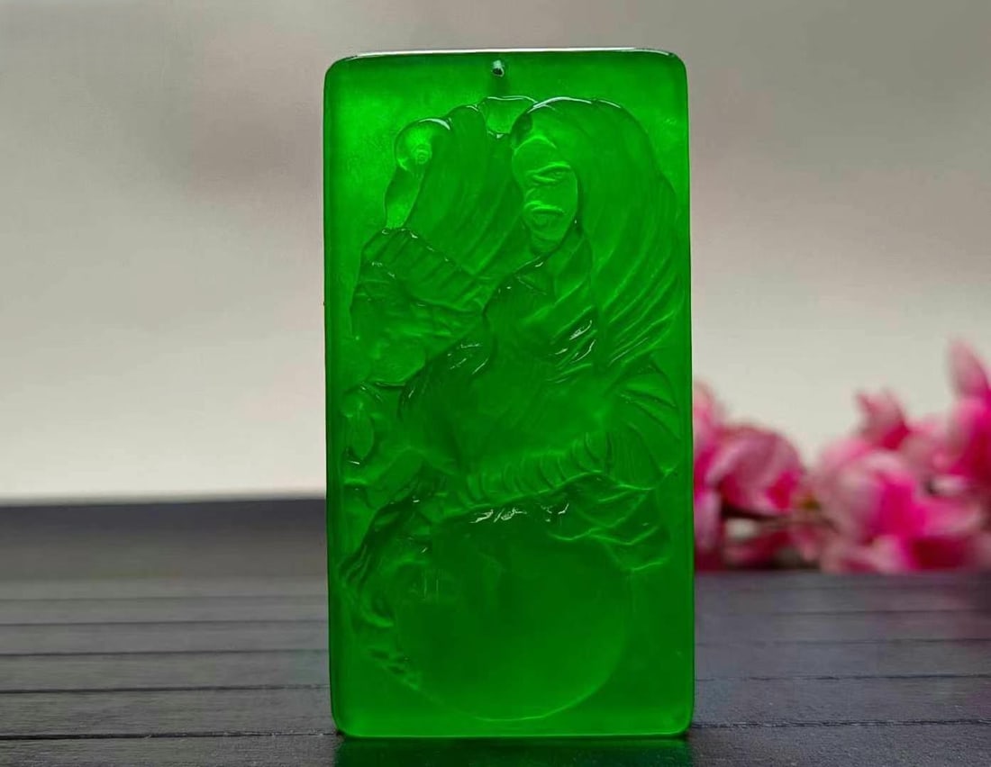Dragon Stone Type Imperial Green Extra Large Jadeite "Power in Hand" Pendant: This is a large, imperial green jadeite pendant in the Dragon Stone variety, symbolizing "Power in One's Hands." The jade is exceptionally translucent with excellent clarity and a lustrous sheen. Its