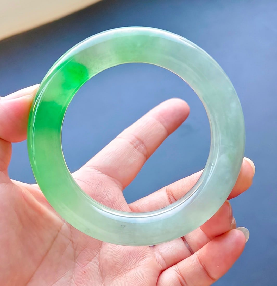 Dragon Stone Jadeite Bangle with Floating Flower Pattern: A jadeite bangle of the dragon stone type with floating green patterns, excellent translucency, absolutely perfect, comes with a certificate from Beijing Yingfangzhai. Provenance:Private collection, M