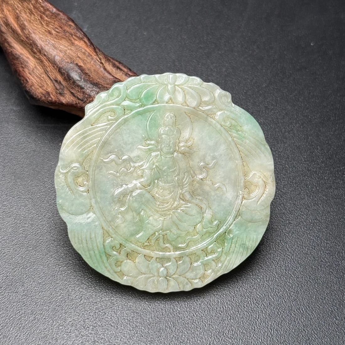 Formerly owned jade pendant, carved with Guanyin in a relaxed posture. (1 of 9)