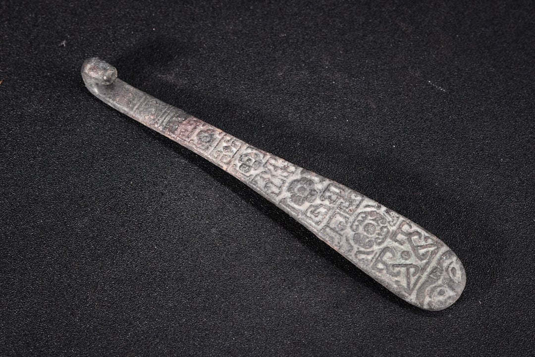 Brass engraved belt hook: A copper belt hook, 19cm long, 3cm wide, and weighing 203g. Provenance:A notable private collector in Kensington, London, United Kingdom. Our cooperative logistics services provider expertly handles b