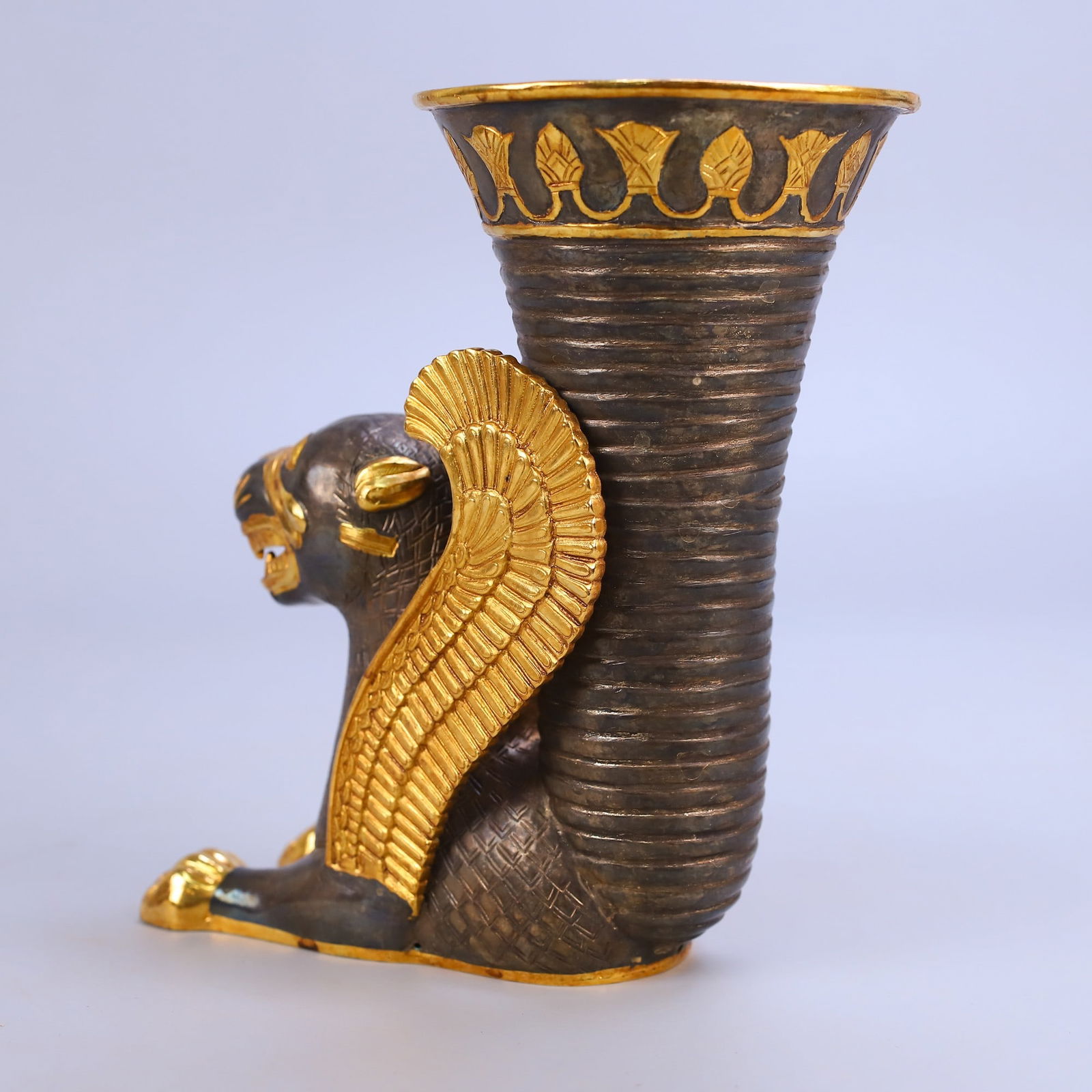 Rare hand-engraved gold winged lion rhyton cup: This is a rare, handcrafted gold-wed lion rhyton, weighing 1071 grams, measuring 18.2 cm in height and 15 cm in width. Its purpose: In ancient Persia, it was a royal drinking vessel, a symbol of power