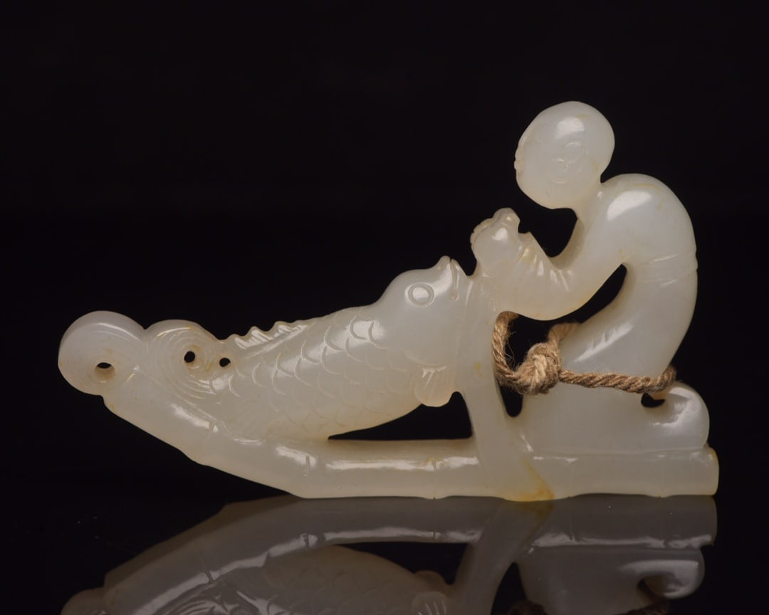 Hetian jade boy playing with fish: Hetian jade child playing with fish. Specifications: 8.0x4.8x1.2cm, weight 50g. The jade is warm and delicate, with natural color patina. The carving is skillful, the skin patina is excellent, the car