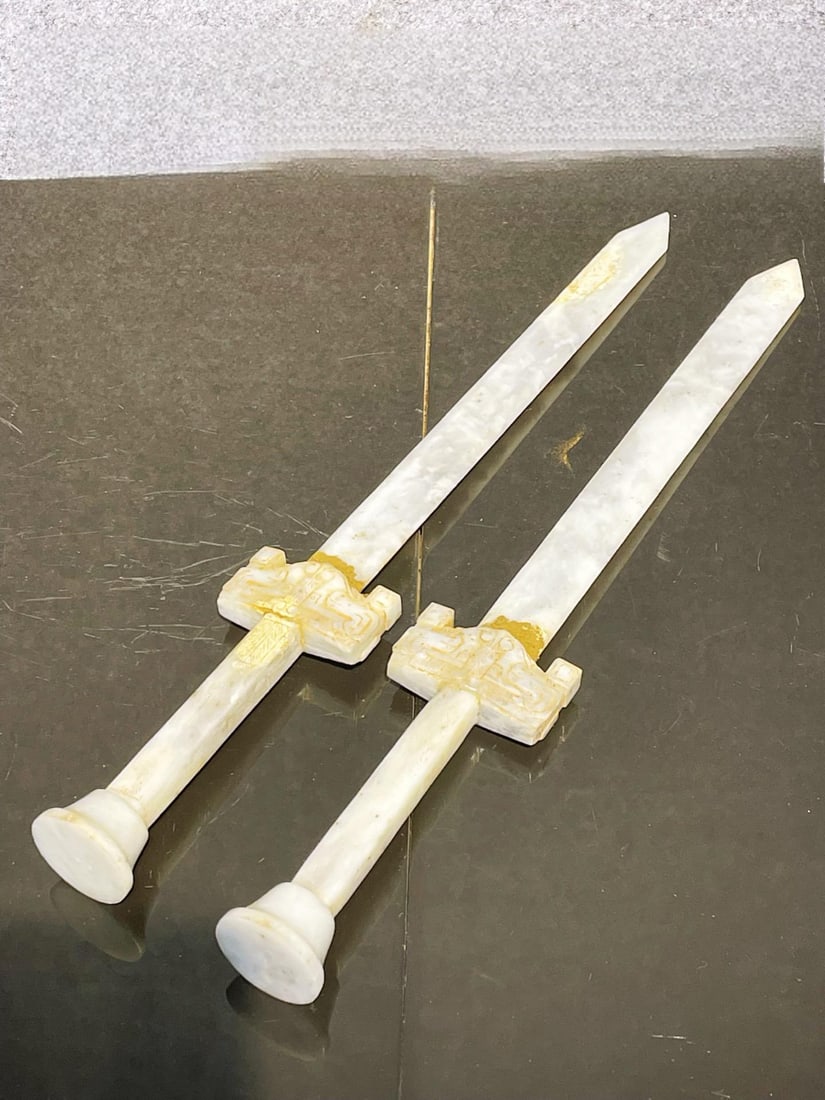 A pair of Hetian jade swords, treasured from the collection.: A pair of treasured Hetian jade swords. Dimensions: 51 x 7.5 cm, Weight: 1.7 g Provenance:Private collection from a professor in University of Glasgow. Our cooperative logistics services provider expe