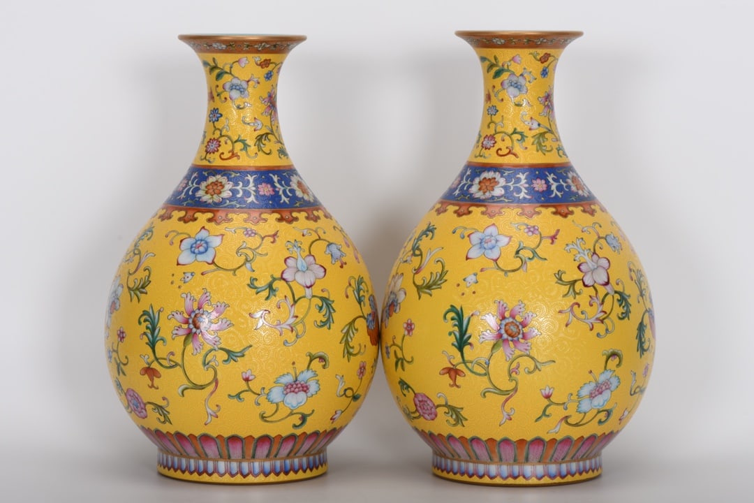 A Qing Dynasty Qianlong period famille rose enamel vase with yellow ground and mixed floral: A Qing Dynasty, Qianlong period, famille rose enamel vase with yellow ground and mixed floral patterns, 30 cm high, 8.8 cm in mouth diameter, 18.5 cm in belly diameter, and 11.6 cm in base diameter. P