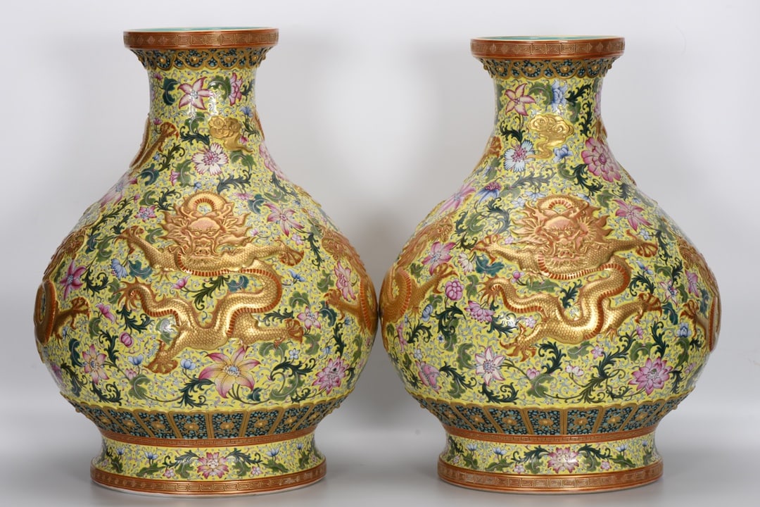 A Qing Dynasty Qianlong period famille rose enamel vase with a yellow ground and carved and gilded: A Qing Dynasty, Qianlong period, famille rose enamel vase with carved and gilded five dragons on a yellow ground, measuring 60.2 cm in height, 20.7 cm in mouth diameter, 45 cm in belly diameter, and 3