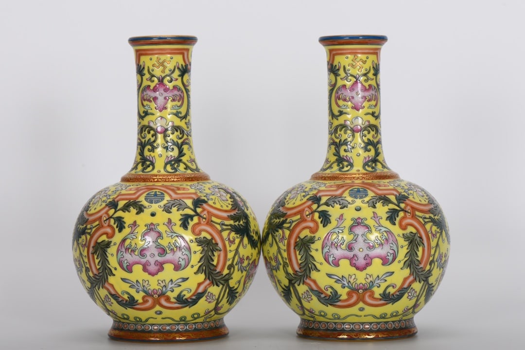 A Qing Dynasty Qianlong period famille rose enamel vase with a yellow ground and decorative: A Qing Dynasty, Qianlong period, famille rose enamel vase with a yellow ground and celestial globe design. Height 18.5 cm, mouth diameter 4.3 cm, belly diameter 11.8 cm, base diameter 7.5 cm. Provenan