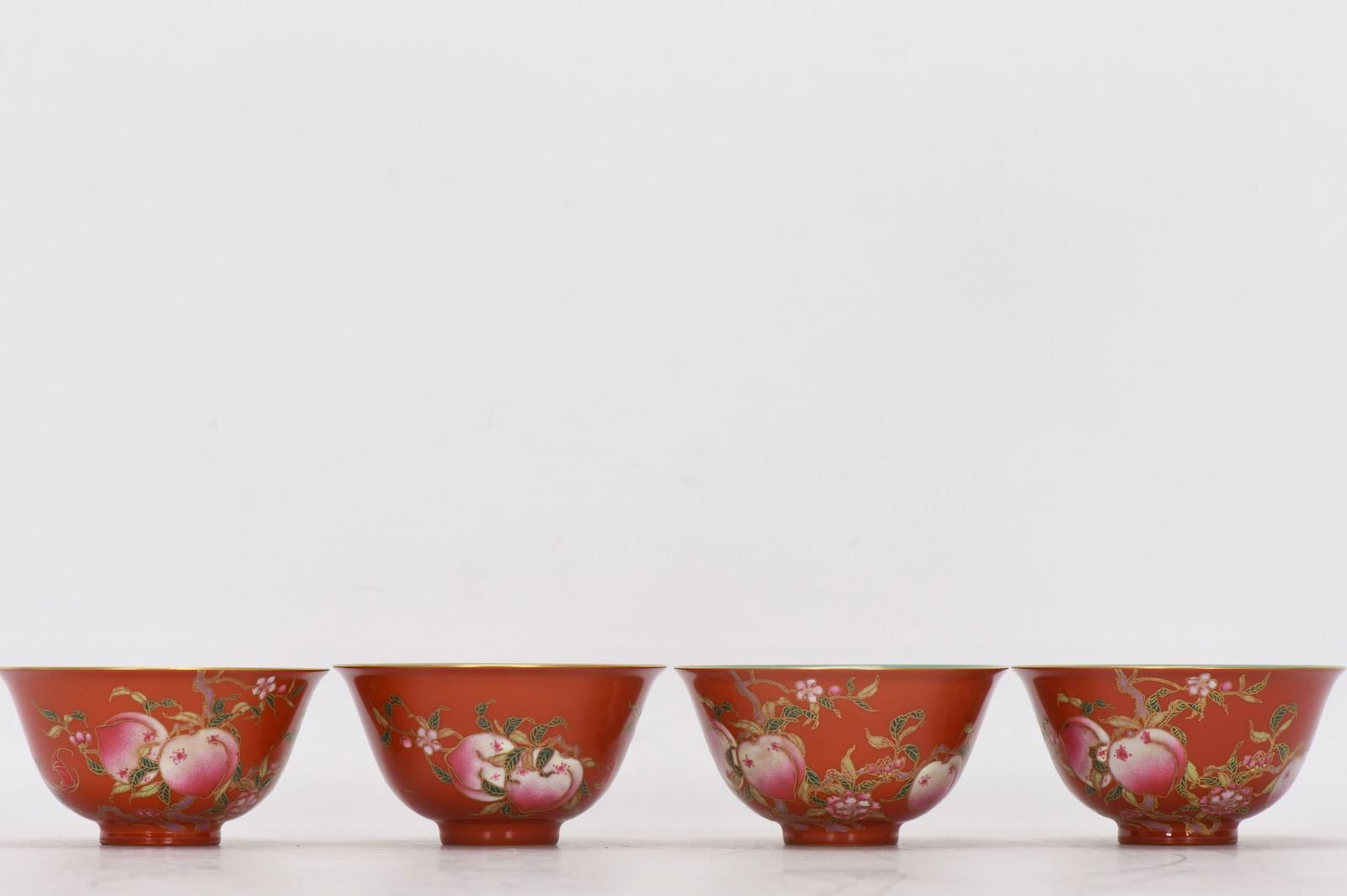 A small enamel bowl with a jujube-red glaze and gold decoration depicting peaches and bats, dating: A small enamel-painted jujube-red bowl with gold-painted peaches and bats, dating to the Qianlong period of the Qing dynasty. Height: 4.9 cm, Mouth diameter: 5.3 cm, Base diameter: 3.1 cm. (Made by Im