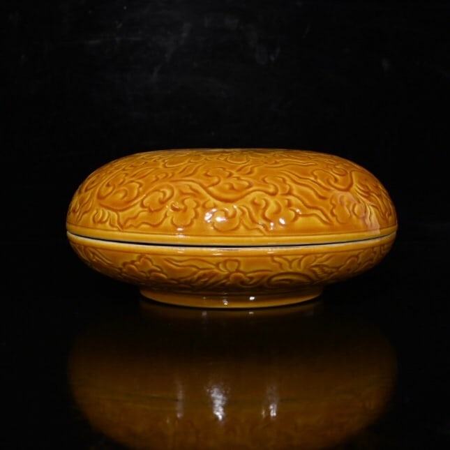 A yellow-glazed powder box with carved peony patterns from the Qianlong period of the Qing Dynasty. (1 of 9)