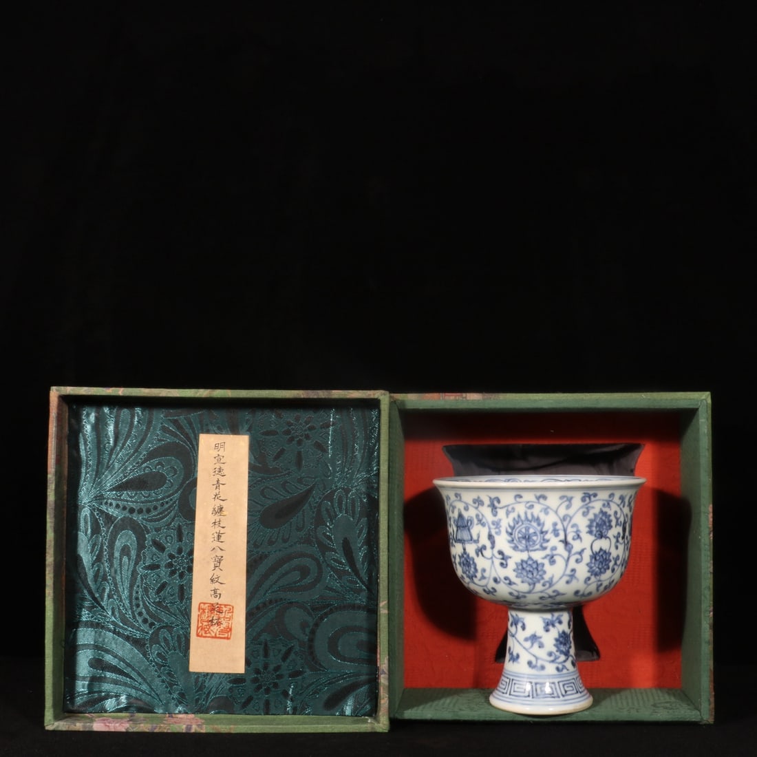 Formerly in the collection: Ming Xuande blue and white stem cup with lotus scroll and eight: A Ming Xuande blue and white stem cup with lotus scroll and eight auspicious symbols, formerly in the collection, measuring 16.5 cm in height and 15.5 cm in diameter. Provenance:Private collection fro