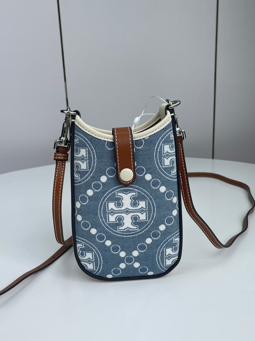Tory Burch jacquard phone case: Tory Burch jacquard phone bag, part of the T Monogram collection, is a shoulder/crossbody bag crafted from select woven jacquard fabric, providing ample space for everyday essentials. It features a