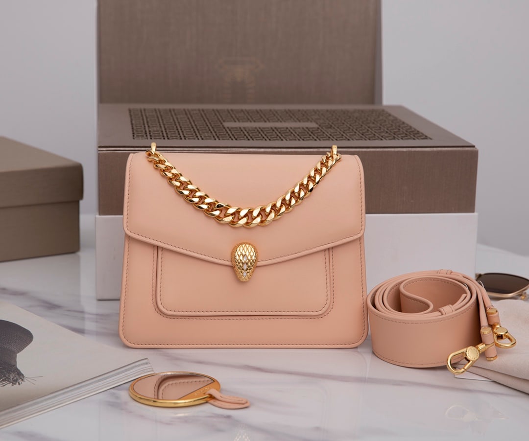 Bvlgari SERPENTI FOREVER: Bvlgari Serpenti Forever small crossbody bag in peach-colored lambskin with a long chain lining, featuring a lavender-amethyst light purple lambskin lining. It has a Serpenti snakehead clasp, adorned 