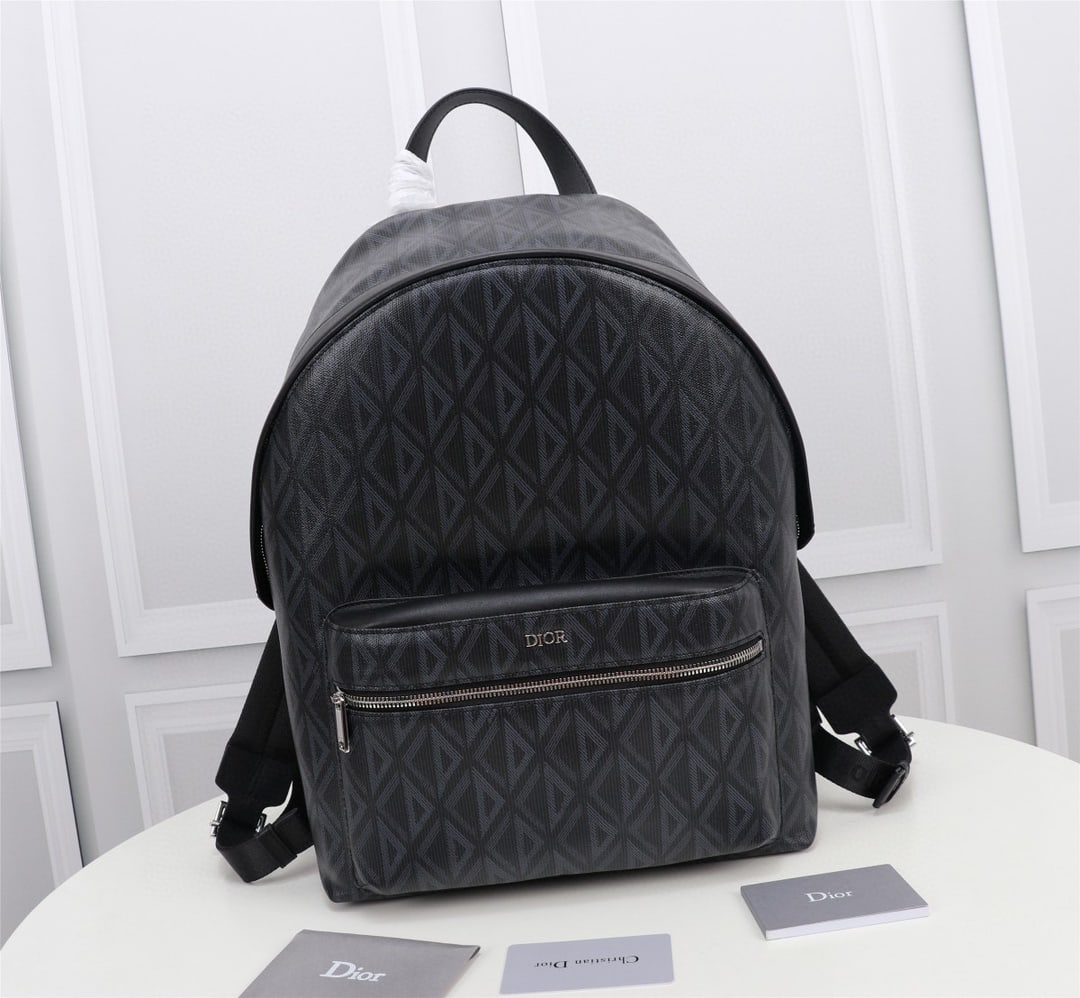Christian Dior: The Rider backpack boasts a minimalist silhouette, its classic preppy style exuding youthful energy. Crafted from black CD Diamond patterned canvas, inspired by the Dior archives, it's accented with s
