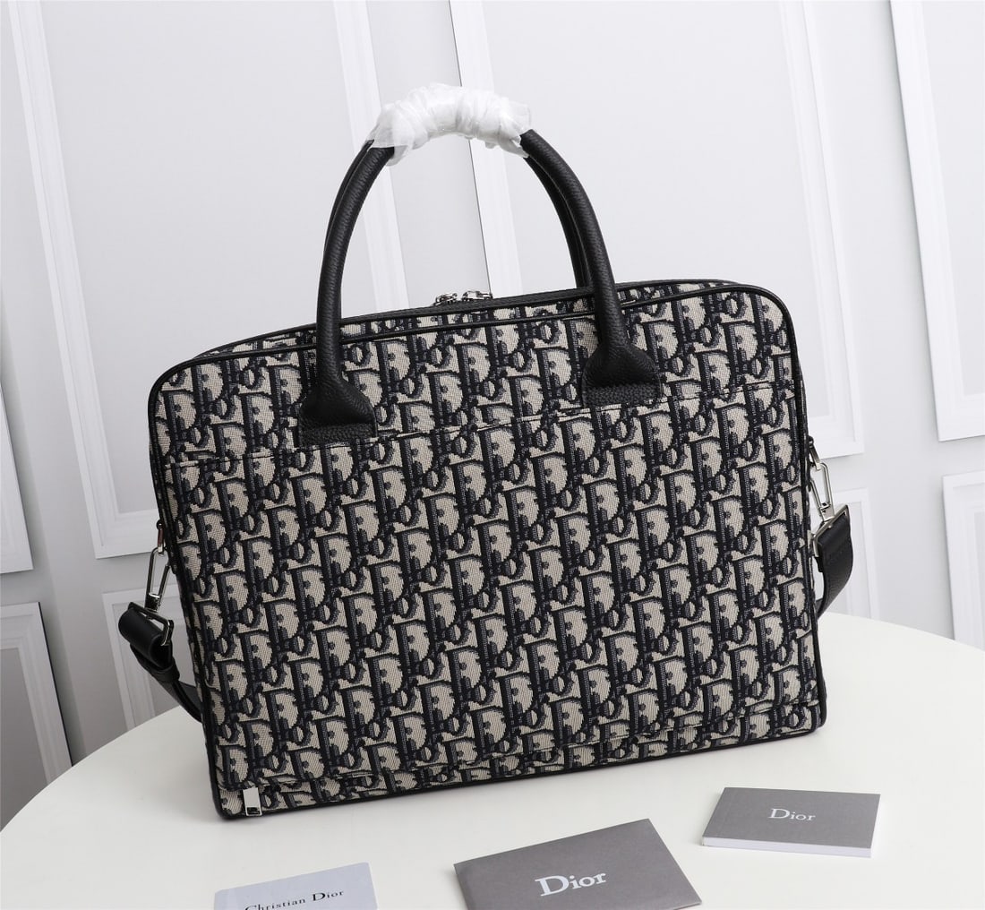 Christian Dior: Black Oblique print jacquard leather, black calfskin, front DIOR logo with embossed DIOR logo inside, adjustable leather shoulder strap, flap with zip closure, interior slip pocket. Can be worn over t