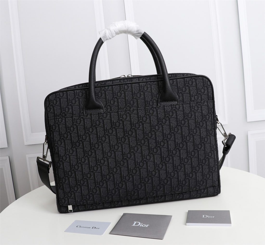 Christian Dior: Black jacquard black Oblique print black calfskin leather. Features a front DIOR logo with embossed DIOR logo inside. Adjustable leather shoulder strap. Flap with zip closure. Interior slip pocket. Ca