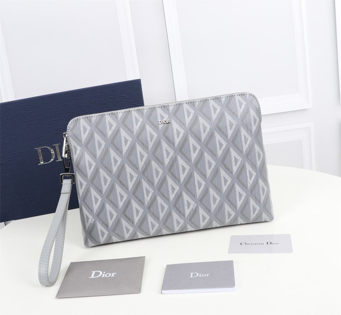 Christian Dior: This clutch is a signature Dior item. Crafted from black CD Diamond patterned canvas, it draws inspiration from the Dior archives, with the DIOR logo adorning the front for added sophistication. It fe