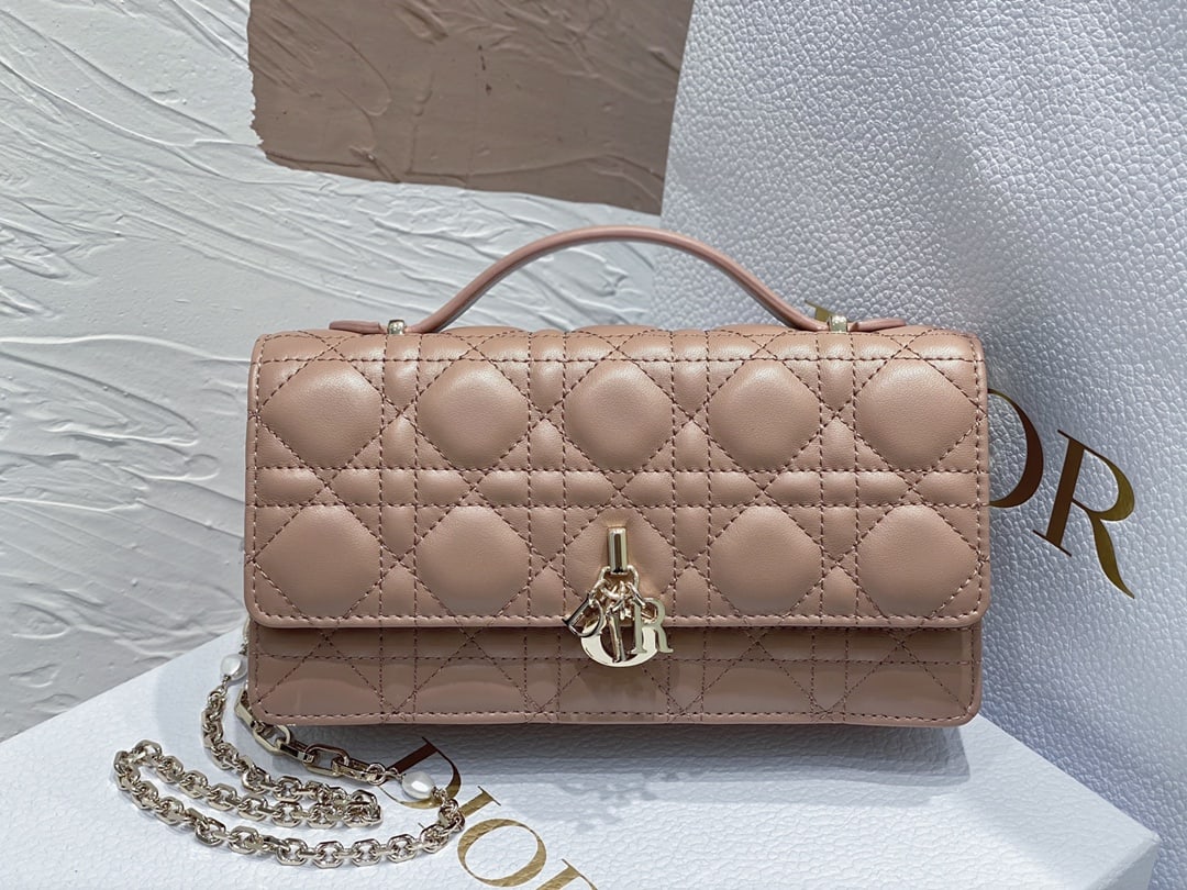 Christian Dior: The Lady Dior Pearl Clutch is an elegant and practical clutch bag that adds to the Lady Dior collection. Crafted from pink lambskin leather with a cannage pattern, its flap design and DIOR charm