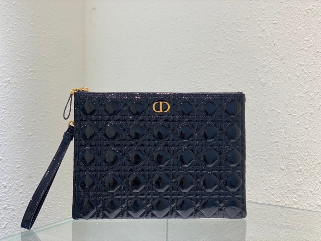 Christian Dior: The Dior Caro everyday clutch is an elegant and practical piece. Crafted from black patent calfskin leather, it features the iconic cannage stitching and a CD logo on the front. The large size can hol