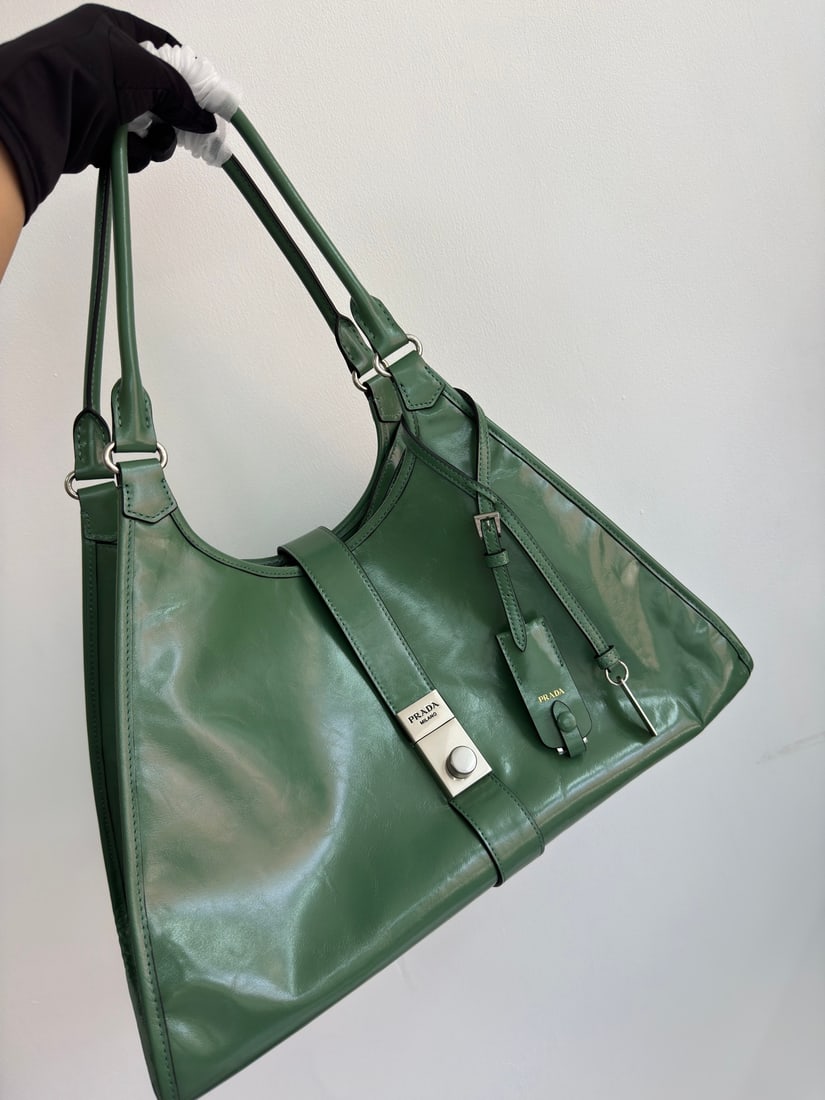 PRADA: This runway piece is made of imported oil-waxed leather and top-quality hardware. It features a snap closure on the front, a large capacity, and can be carried by hand or over the shoulder. It has a v