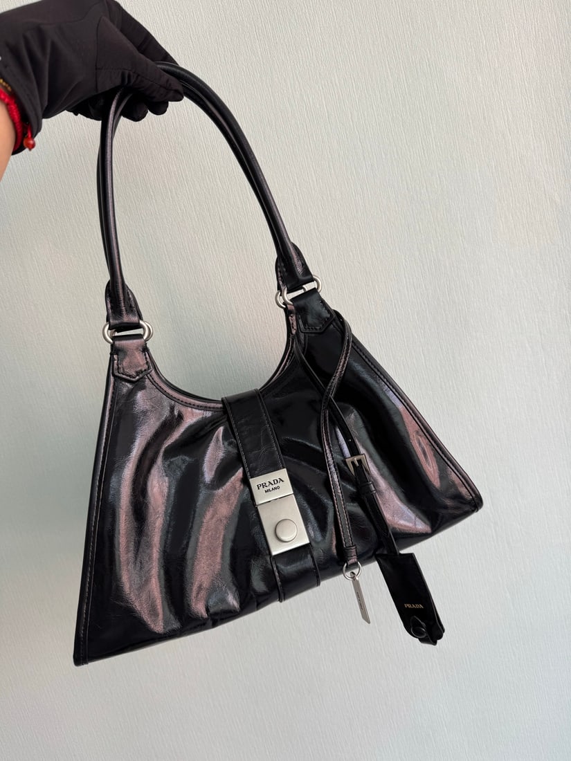 PRADA: This runway piece is made of imported oil-waxed leather and top-quality hardware. It features a snap closure on the front, a large capacity, and can be carried by hand or over the shoulder. It has a