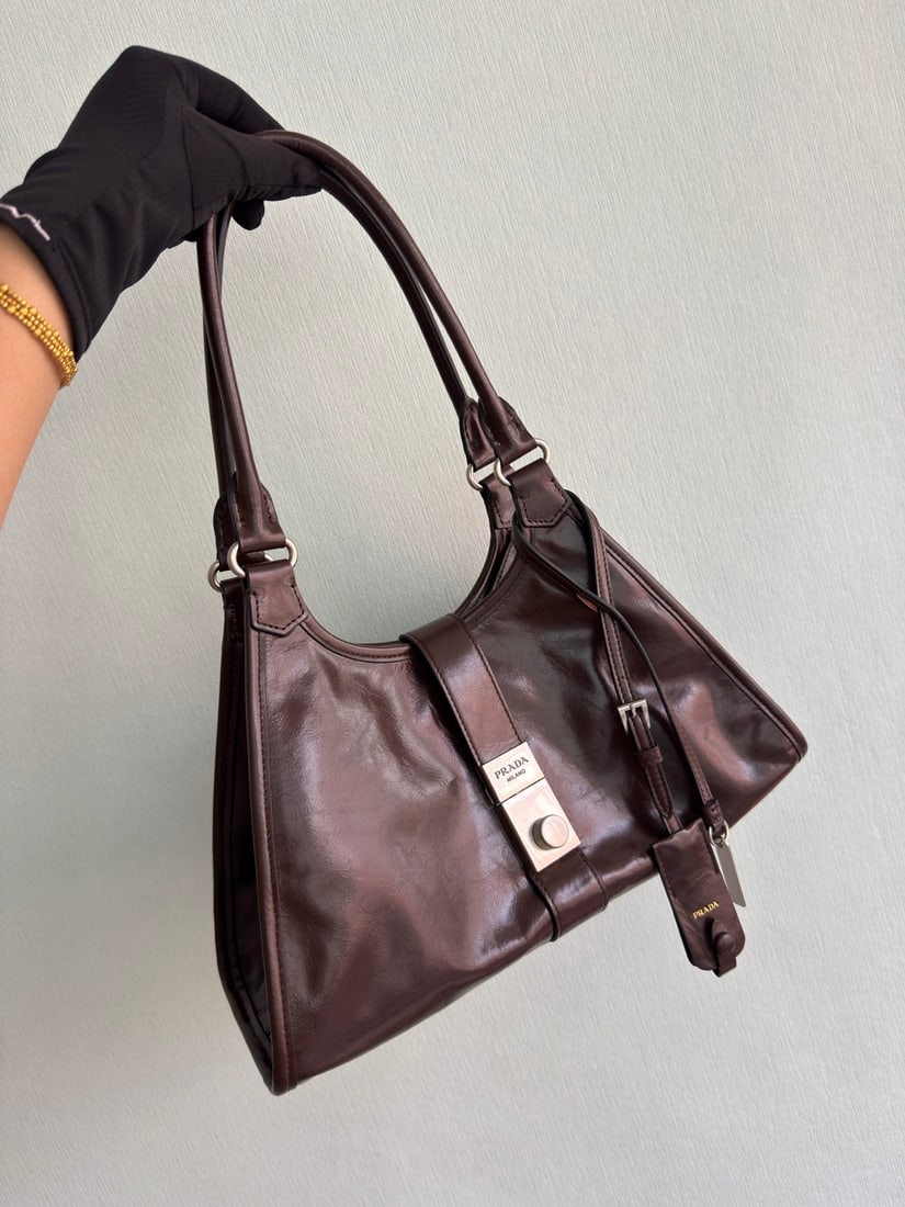PRADA: This runway piece is made of imported oil-waxed leather and top-quality hardware. It features a snap closure on the front, a large capacity, and can be carried by hand or over the shoulder. It has a v
