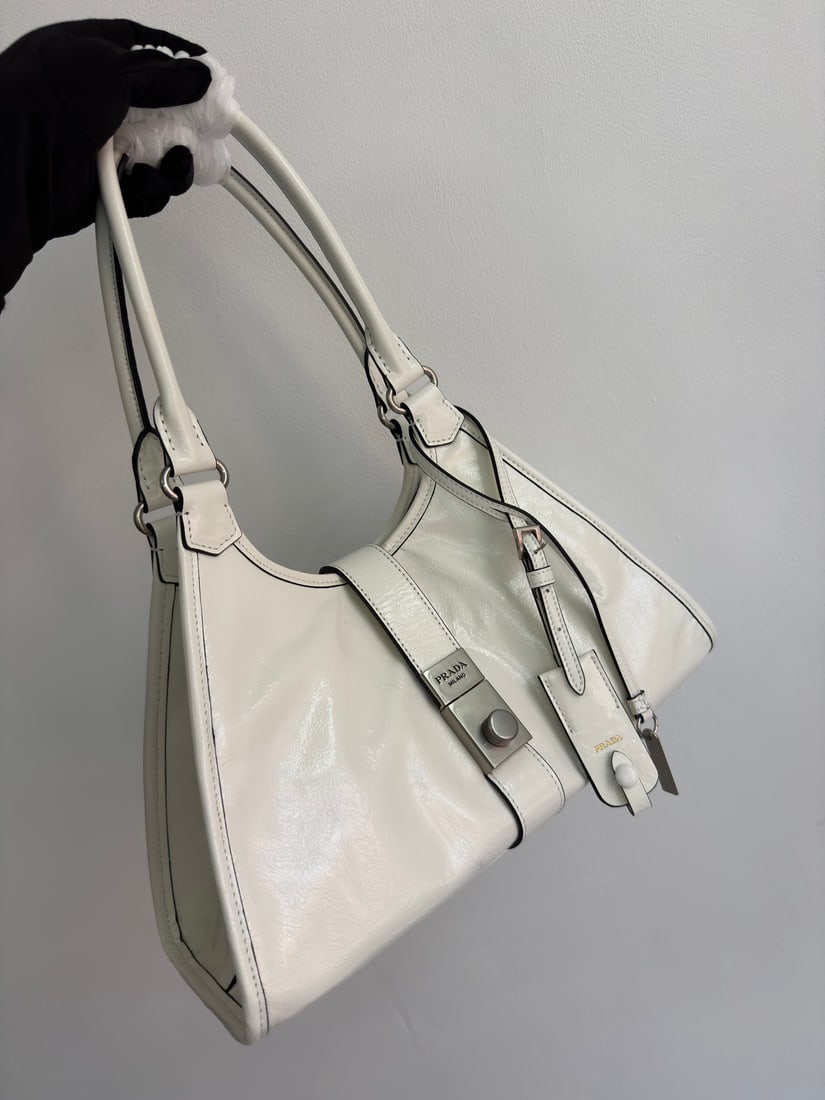 PRADA: This runway piece is made of imported oil-waxed leather and top-quality hardware. It features a snap closure on the front, a large capacity, and can be carried by hand or over the shoulder. It has a v