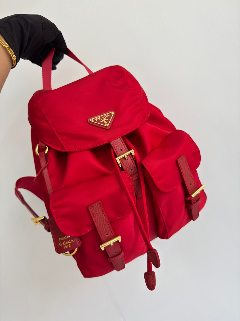 PRADA Classic Backpack with Gold Buckle: This classic backpack with gold buckles is both practical and innovative. Made with imported nylon fabric, it features adjustable shoulder straps and a woven handle, a detachable Re-Edition leather