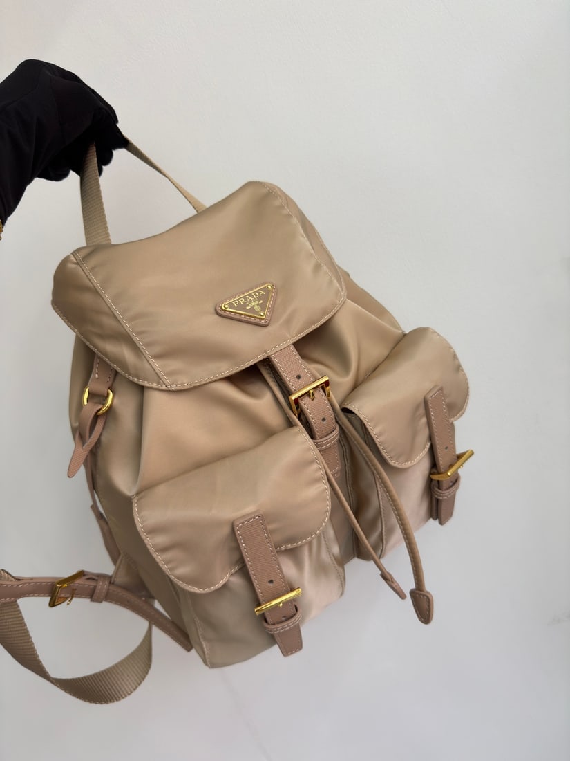 PRADA Classic Backpack with Gold Buckle: This classic backpack with gold buckles is both practical and innovative. Made with imported nylon fabric, it features adjustable shoulder straps and a woven handle, a detachable Re-Edition leather ke