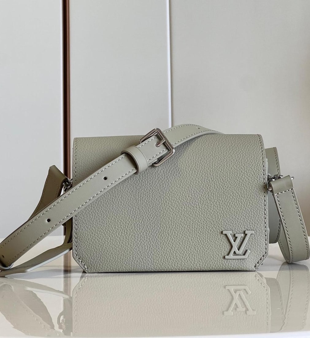LV Fastline: The grey Fastline mini handbag combines grained calfskin with a distinctive Aerogram design, accented by a bias-cut flap detail and LV lettering on the front corner. A detachable shoulder strap