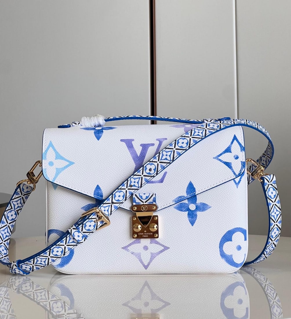 LV POCHETTE METIS: The Pochette Metis handbag features a watercolor effect of LV monogram and Monogram flowers on canvas, with intricate Monogram flowers adorning the top handle and detachable shoulder strap, drawing