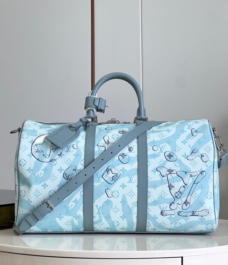 LV Keepall BandouliEre: The Keepall BandouliEre 50 travel bag in a teardrop green hue is crafted from Monogram Aquagarden canvas, giving the Monogram flowers and LV logo a three-dimensional teardrop appearance, seemingly