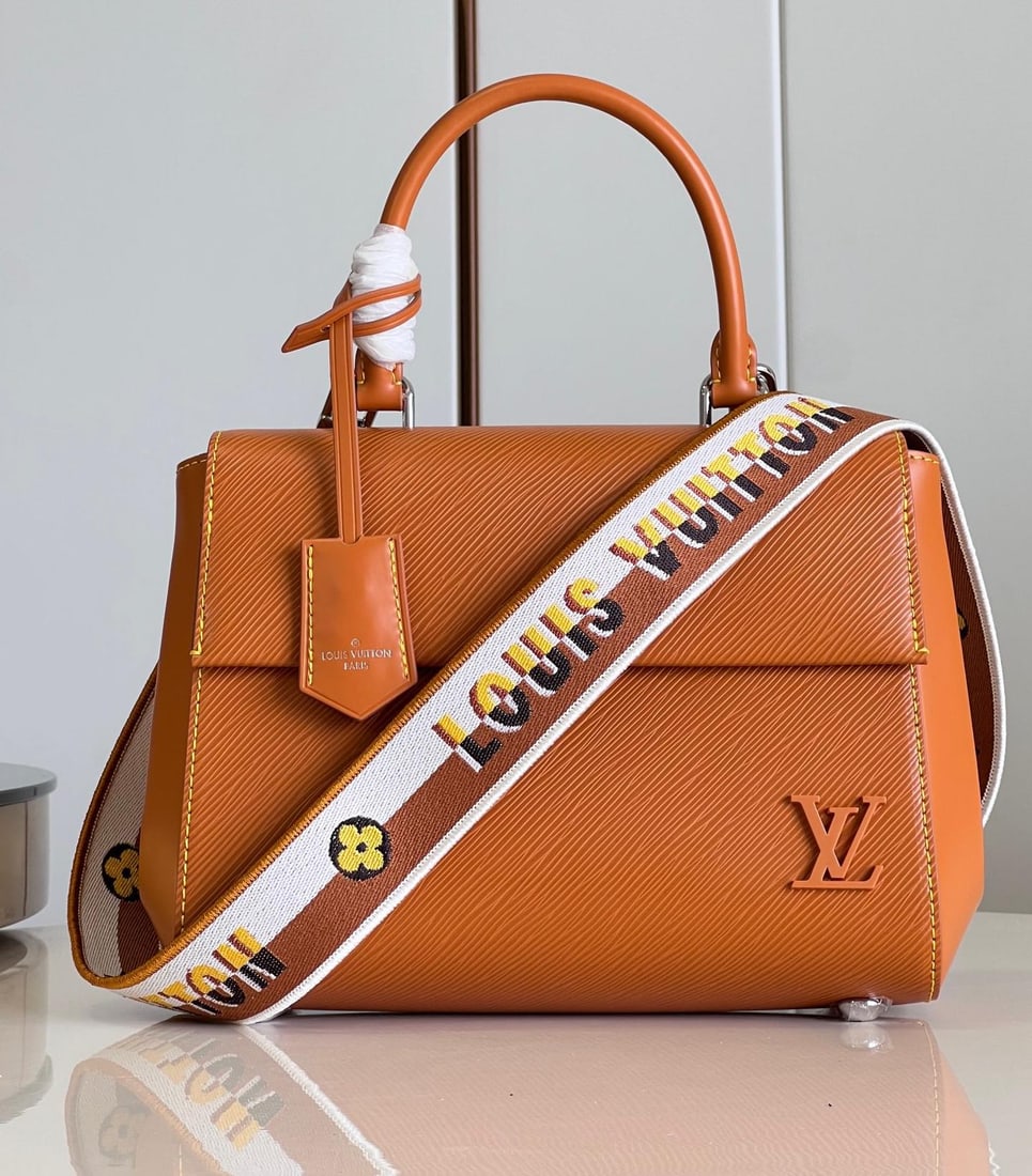 LV Cluny: The Cluny BB handbag features a novel twill pattern on Epi leather, paired with a smooth resin LV logo and a bright lining. The detachable reversible shoulder strap, with its vibrant jacquard, exudes