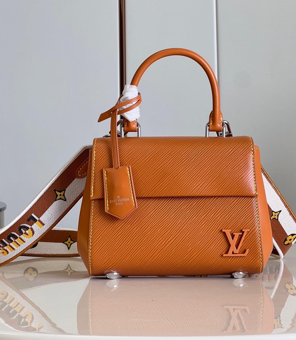LV Cluny: The Cluny mini handbag showcases two styles with its detachable jacquard shoulder strap: the LV logo proclaims the brand identity, while flipping it reveals the subtle blooming of the Monogram