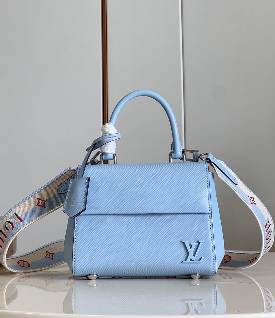 LV Cluny: The Cluny mini handbag showcases two styles with its detachable jacquard shoulder strap: the LV logo proclaims the brand identity, while flipping it reveals the subtle blooming of the Monogram flower.