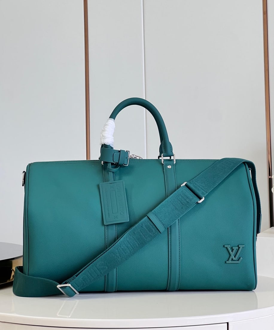 LV Keepall BandouliEre: The Keepall BandouliEre 50 handbag is from the LV Aerogram series, combining a cowhide leather body, leather trim, a top handle, and an LV-logo fabric shoulder strap. The LV lettering in the corner ex
