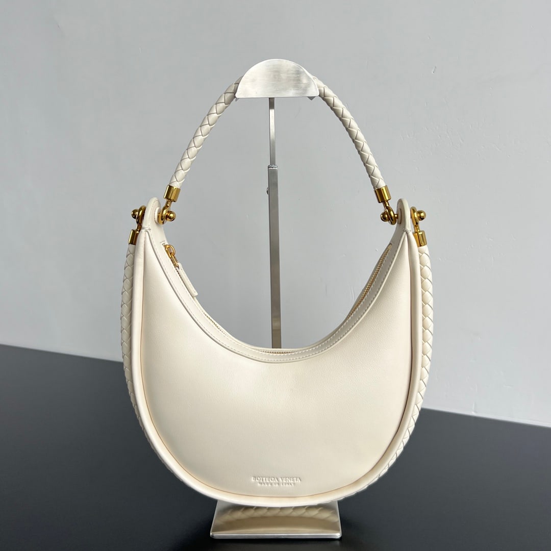 Bottega Veneta Half-Moon Bag: The Bottega Veneta Half Moon Bag is an exquisite yet relaxed half moon bag crafted from imported lambskin, offering a delicate and soft touch. A round buckle cleverly connects two hand-woven shoulder 