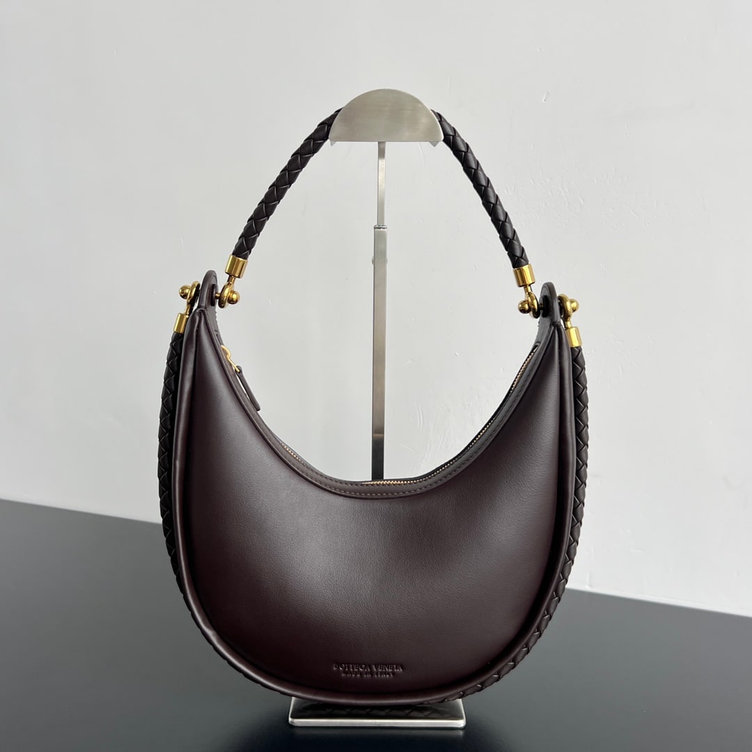 Bottega Veneta Half-Moon Bag: The Bottega Veneta Half Moon Bag is an exquisite yet relaxed half moon bag crafted from imported lambskin, offering a delicate and soft touch. A round buckle cleverly connects two hand-woven shoulder 