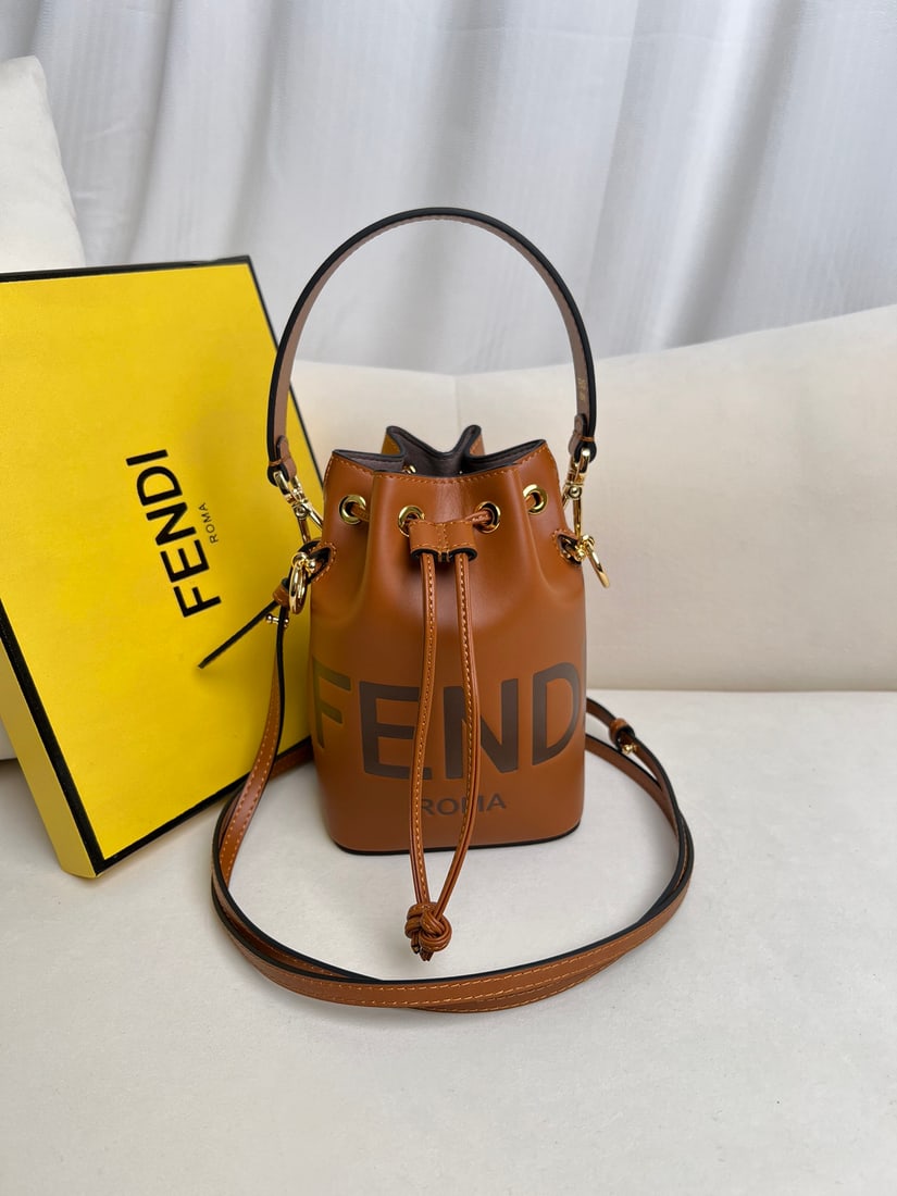 Fendi Mon Tresor: Brown Mon Tresor mini bucket bag in light blue leather. Features a drawstring closure and Fendi logo hardware. Comes with two detachable shoulder straps (one long, one short) for hand-carrying,