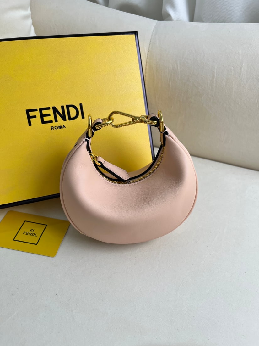 FENDI Praphy: This small pink FENDI Praphy underarm bag features a crescent shape and a classic large metal logo at the bottom. The bag's silhouette hugs the body's lines, creating a stylish look when worn under