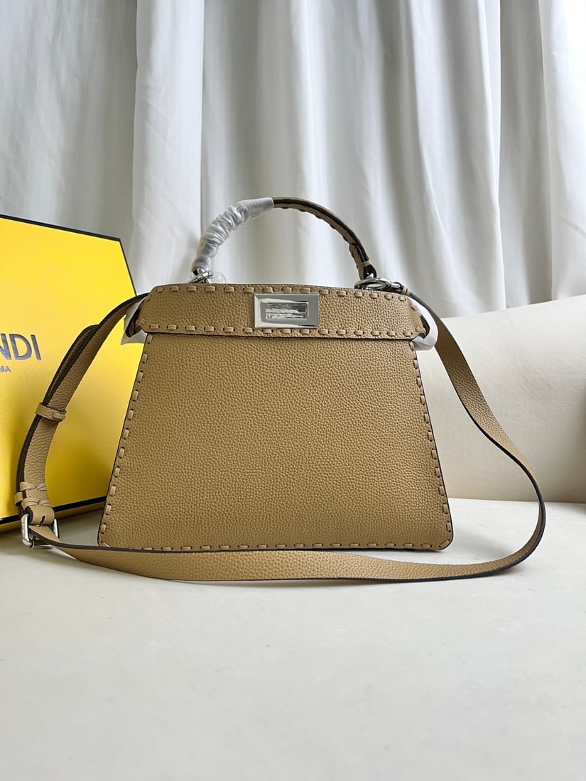 FENDI PeekabooISeeU: This apricot-colored FENDI Peekaboo I See U medium-sized handbag is crafted from pebbled calfskin leather, featuring classic twist locks on both sides, a soft Nappa leather lining, two compartments